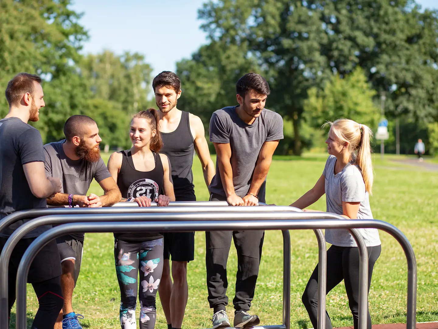 Junge Sportler im Park hinter Stangen.