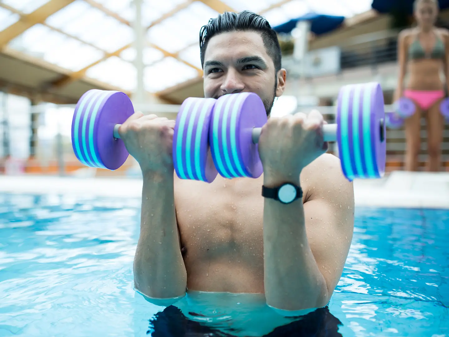 Ein junger Mann trainiert im Wasser mit Aqua-Fitness.