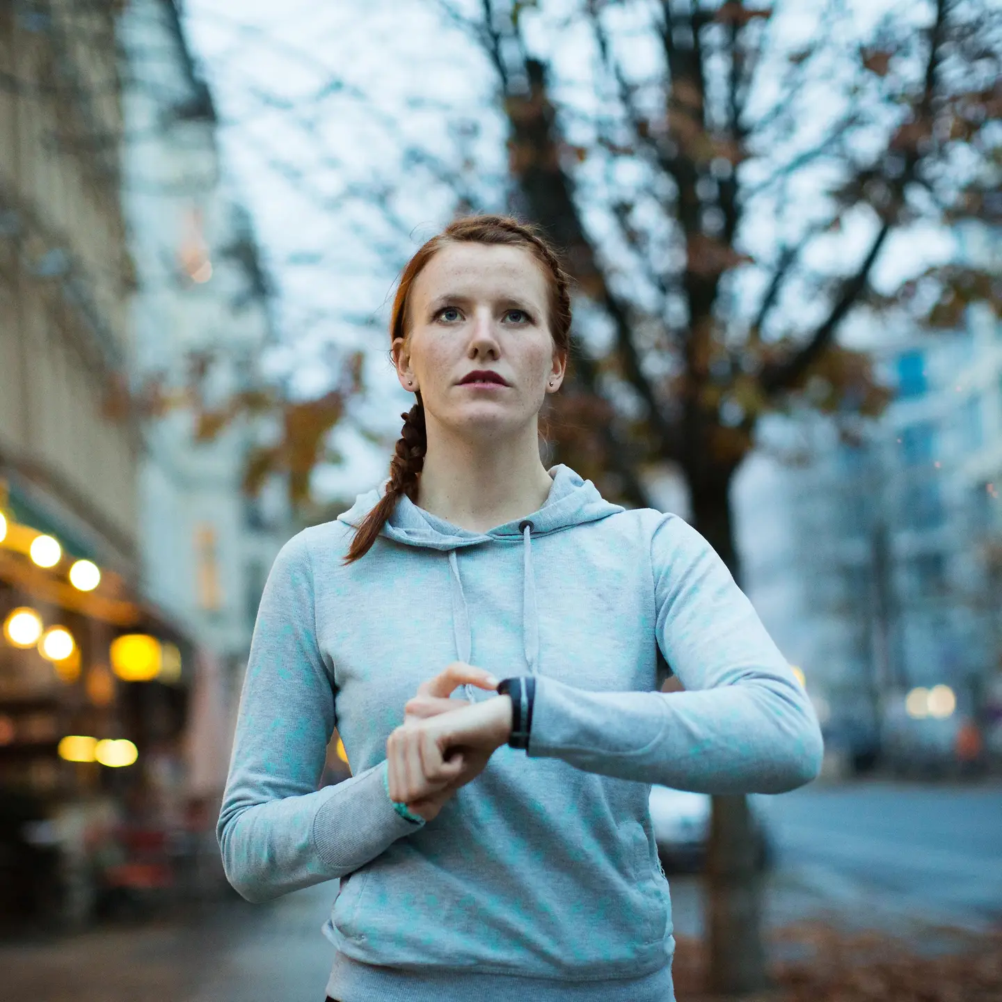 Eine Frau macht draußen Sport und checkt ihre Fitnessuhr