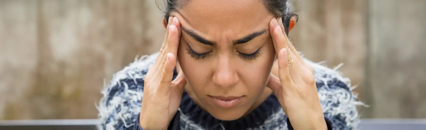 Frau mit Kopfschmerzen reibt sich die Schläfen