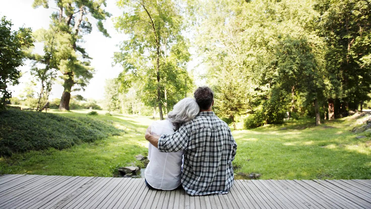 Ein jüngerer Mann sitzt mit einer älteren Frau auf der Veranda im Garten_var