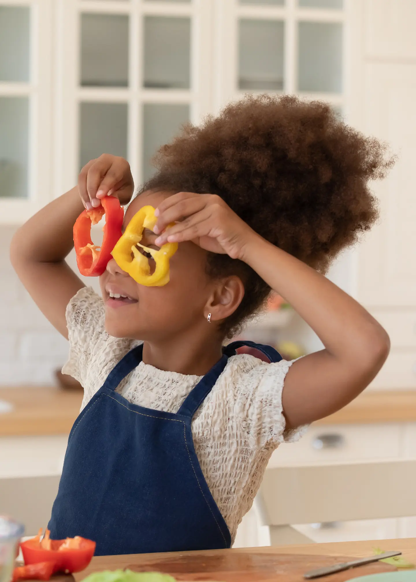 Eine Mutter schneidet mit ihrer Tochter Paprika in Scheiben 