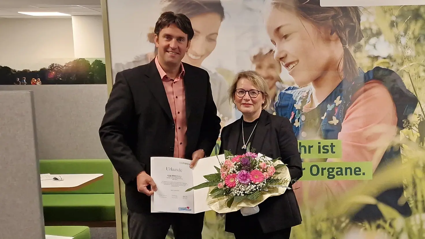 Dominik Werle überreicht Anja Watermann eine Urkunde und einen Blumenstrauß.