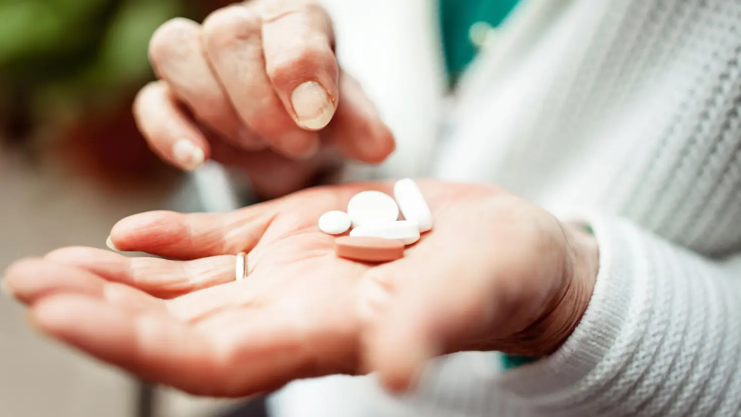 Zu sehen ist eine offene Hand die, Tabletten hält