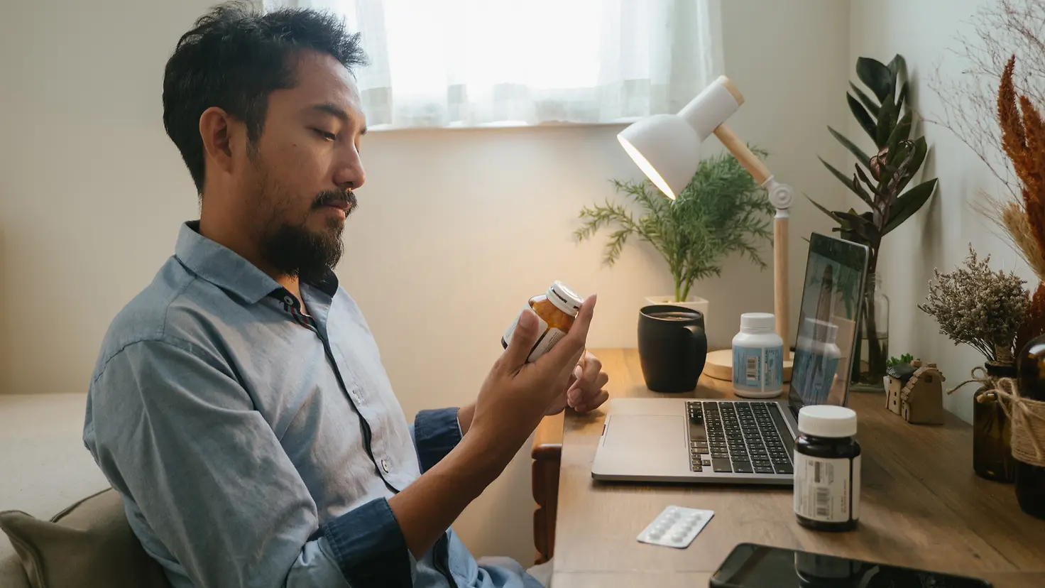 Eine junger Mann informiert sich über die Nebenwirkungen seiner Antidepressiva