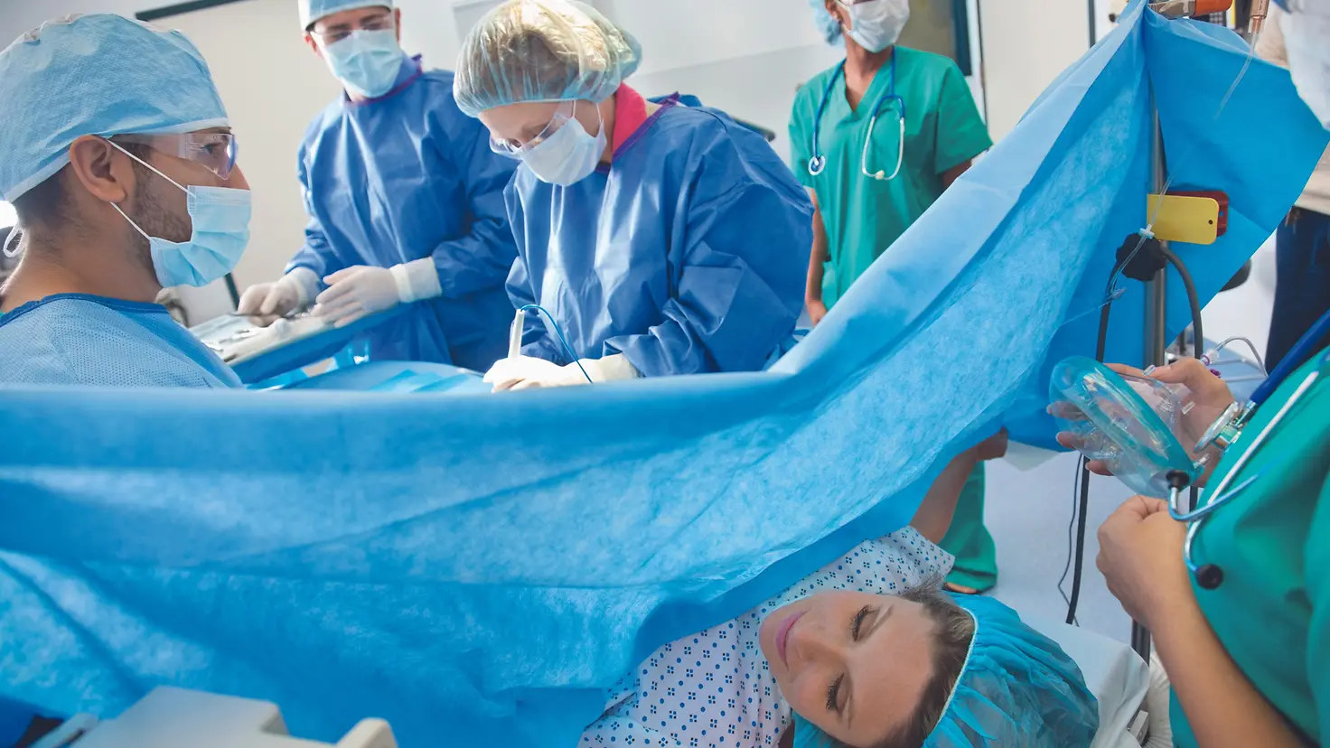 Chirurgisches Team, das Kaiserschnitt an einer schwangere Frauen durchführt.